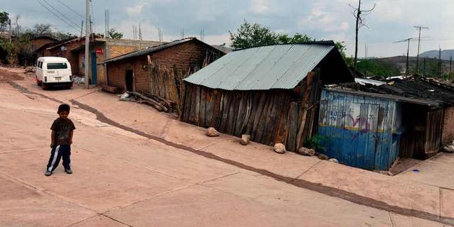 A child stands on a street of the Acatempa village, Chilpancingo, Guerrero state in Mexico on April 26, 2013. Some 1,000 people have fled their homes in southwestern Mexico after gunfights erupted in their villages and criminal groups threatened them, officials said Thursday.