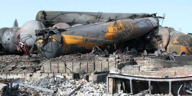 This picture released by Quebec police (Surete du Quebec) on July 12, 2013 shows burnt train wagons in Lac-Megantic following the derailment and explosion of a train loaded with crude oil on July 6. Canada's two largest railways said they are reviewing procedures for securing stopped trains, pending new federal rules following the derailment of a runaway train in Quebec.