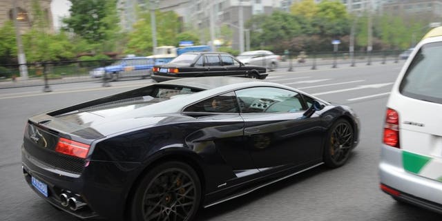 This file illustration photo shows a luxury car, on a Shanghai street, on April 18, 2013. Scandals of government officials living lavishly -- with luxury watches, multiple mistresses or fancy cars for their children -- are frequently reported in the domestic press. President Xi Jinping has warned graft could destroy the party and that offenders would receive no leniency.