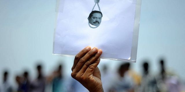 A student holds a poster featuring Sri Lanka's president in a protest over alleged war crimes against Tamils in Sri Lanka, in Chennai, India on March 20, 2013. European parliamentarians Friday asked Sri Lanka to deliver on promises to investigate allegations of war crimes and ensure ethnic reconciliation more than four years after crushing Tamil separatists.