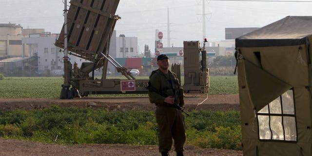 An Israeli soldier stands in front of an "Iron Dome" short-range missile defence system near the northern Israeli city of Haifa on May 6, 2013. Israel deployed its Iron Dome missile defence system near the Red Sea resort of Eilat, which is close to the border with Egypt, an army spokeswoman said.