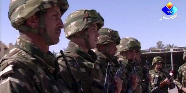 An image grab taken from footage provided by Algeria's Ennahar TV on January 18, 2013 and filmed in June 2012 shows Algerian soldiers standing to attention in the desert at an undisclosed location in the south of the country. Algerian soldiers shot dead four Islamists during an overnight raid in the town of Sour El-Ghozlane southeast of the capital Algiers, security sources said.
