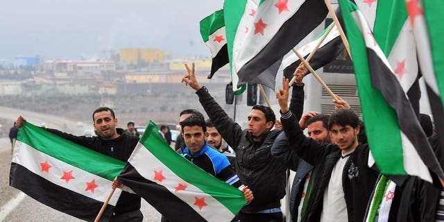 Activists, including some artists, wave a Syrian flag against president Bashar al-Assad during rally on January 12, 2012, in Kilis. The wife of acclaimed Syrian artist Youssef Abdelke, whose works are displayed in museums around the world, appealed for his release on Saturday, after his arrest by regime security forces.