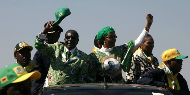 Zimbabwe's President Robert Mugabe (2nd L) waves as he arrives to address crowds gathered during an election campaign rally held at Chibuku Stadium, in Chitungwiza on July 16, 2013. Mugabe on Saturday warned South Africa's Jacob Zuma to stop his top mediator from commenting on the country's political crisis, as the veteran leader stepped up electioneering.