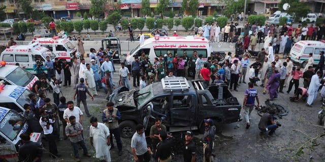 Pakistani security personnel collect evidence at the site of a bomb attack in Karachi on July 20, 2013. Two separate bomb explosions late Saturday killed four people and wounded seven others in Pakistan's port city Karachi, police said.