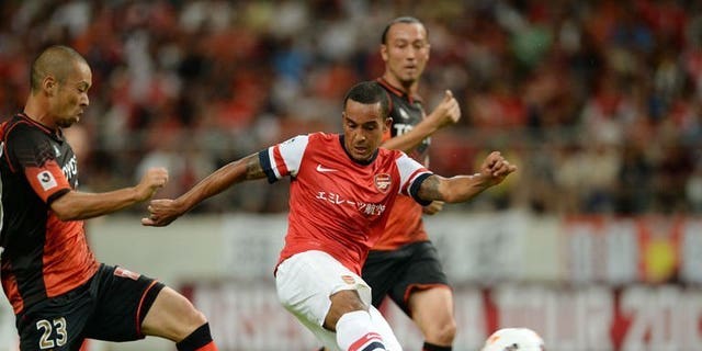 Arsenal forward Theo Walcott (C) shoots towards goal between Nagoya Grampus defenders during their friendly in Toyota, Japan's Aichi prefecture on July 22, 2013. French striker Olivier Giroud struck his sixth goal in three Asian tour games as Arsenal marked manager Arsene Wenger's return to his former club Grampus with a 3-1 win on Monday, with England's Walcott adding a third after half-time.