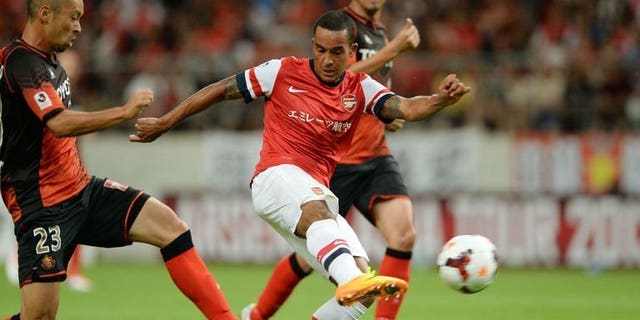 Arsenal forward Theo Walcott (C) shoots towards goal between Nagoya Grampus defenders during their friendly in Toyota, Japan's Aichi prefecture on July 22, 2013. French striker Olivier Giroud struck his sixth goal in three Asian tour games as Arsenal marked manager Arsene Wenger's return to his former club Grampus with a 3-1 win on Monday, with England's Walcott adding a third after half-time.