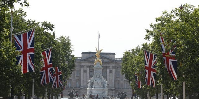 Britain's Union flags fly on the Mall leading to Buckingham Palace (background) in central London, on July 22, 2013. Prince William's wife Kate on Monday gave birth to a baby boy who will one day be heir to the British throne, Kensington Palace said in a statement.