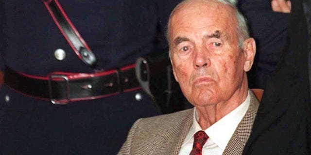 This file picture taken on July 30, 1996 shows former German SS officer Erich Priebke surrounded by police at a military court in Rome. The 100th birthday of Priebke -- one of the last Nazi criminals alive -- has sparked calls for a public apology from relatives of his victims 69 years after their murder and resentment over his freedom of movement.