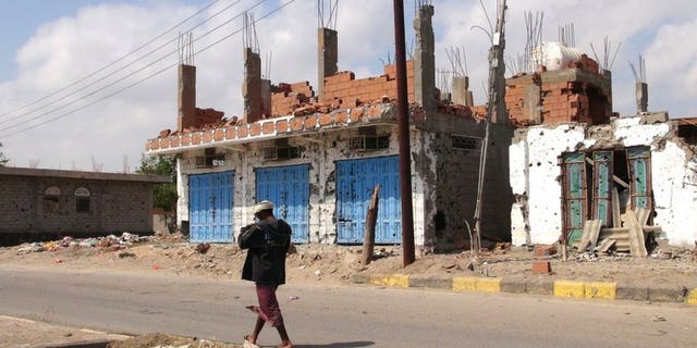 A Yemeni man walks past destroyed buildings in Zinjibar, capital of Abyan province in southern Yemen on December 5, 2012. Yemeni authorities have released a journalist who had been detained for three years on charges of promoting Al-Qaeda, the state news agency Saba reports.