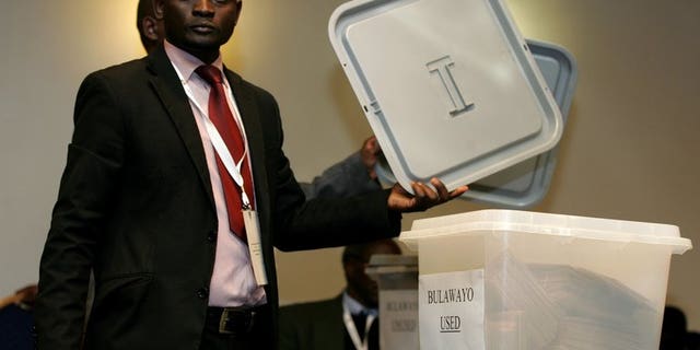 An official from the Zimbabwe Electoral Commission (ZEC) shows a lid before sealing a ballot box in harare on July 19, 2013. Zimbabwe election authorities insisted Tuesday that they would be ready to hold general elections in a week's time, despite fears of vote rigging and a lack of funding.