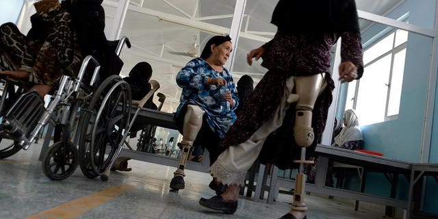 An Afghan amputee practices walking with her prosthetic leg at one of the International Committee of the Red Cross (ICRC) hospitals for war victims and the disabled in Kabul June 5, 2013. The Red Cross said Tuesday it will shut down three of its 17 offices in Afghanistan, two months after an unprecedented militant attack on the organisation.