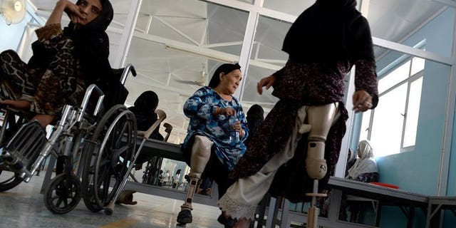 An Afghan amputee practices walking with her prosthetic leg at one of the International Committee of the Red Cross (ICRC) hospitals for war victims and the disabled in Kabul June 5, 2013. The Red Cross said Tuesday it will shut down three of its 17 offices in Afghanistan, two months after an unprecedented militant attack on the organisation.