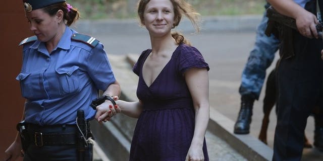 File picture shows Maria Alyokhina, a member of punk band "Pussy Riot," being escorted into court in Moscow on August 8, 2012. Alyokhina on Wednesday asked again to be released on parole after serving almost a year in prison for a protest againt President Vladimir Putin in a Moscow church.