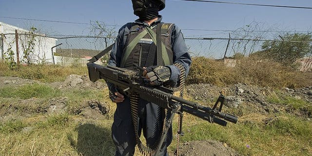 A Mexican policeman stands guard in Apatzingan, Michoacan State, on December 12, 2010. Heavily-armed men have assaulted Mexican federal police units in a carefully planned attack in which 22 people were killed in six towns, according to the government.