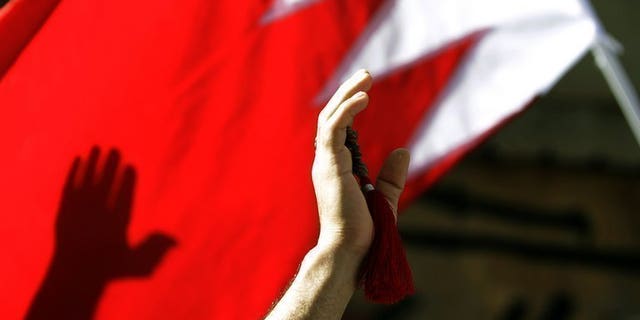 A Shiite protester waves a Bahrain flag during a rally in Manama, on March 22, 2011. Bahrain police say they have recaptured two men suspected of attacks on security forces, two months after they escaped from custody along with other detainees.