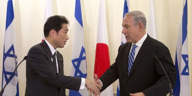 Japanese Foreign Minister Fumio Kishida (left) shakes hands with Israeli Prime Minister Benjamin Netanyahu during a joint press conference in Jerusalem, on July 24, 2013. Netanyahu has urged greater pressure on Iran over its nuclear programme as he met Kishida.