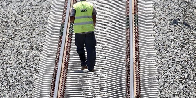 An employee of the Spanish National Railway Company (RENFE) is seen on the tracks in Valencia on June 23, 2010. Between 15 and 20 people have died after a train derailed in northwestern Spain on Wednesday, according to the El Pais and El Mundo dailies.