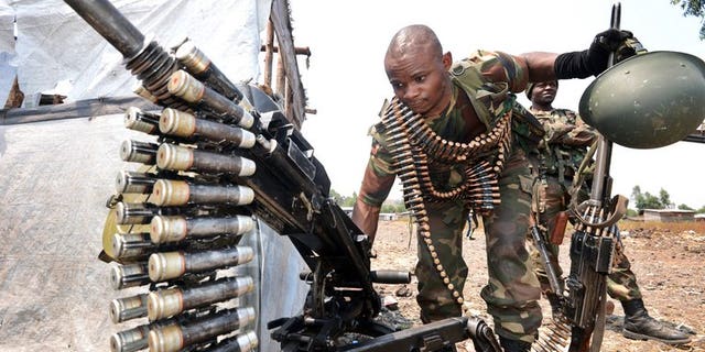 A soldiers of the FARDC government forces mans a machine gun on the front line in Kanyaruchinya, 15km from Goma on July 24, 2013, as rebels claimed today they had killed more than 400 army troops since fighting resumed 10 days ago in the Democratic Republic of Congo's volatile east, as each side accused the other of new attacks.