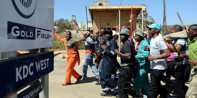 Striking Gold Fields mine workers march on September 11, 2012 in Carletonville, west of Johannesburg. Gold miners have vowed to take their silicosis lawsuit against London-listed Anglo American to South Africa's courts, after a British court refused to hear their case.