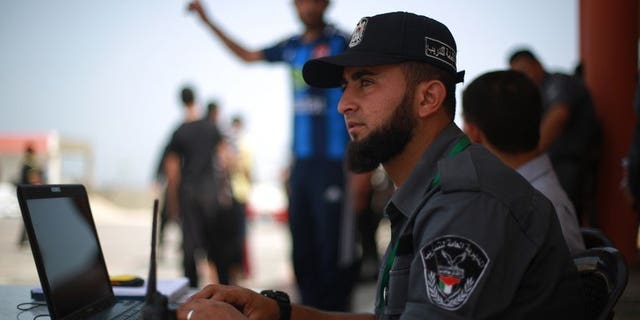 A Hamas policeman sits at his laptop in Gaza City on June 2, 2013. Authorities in the Hamas-ruled Gaza Strip on Thursday closed local offices of Al-Arabiya TV and Palestinian news agency Maan for alleged "false" reporting of Hamas help for Egypt's Muslim Brotherhood.
