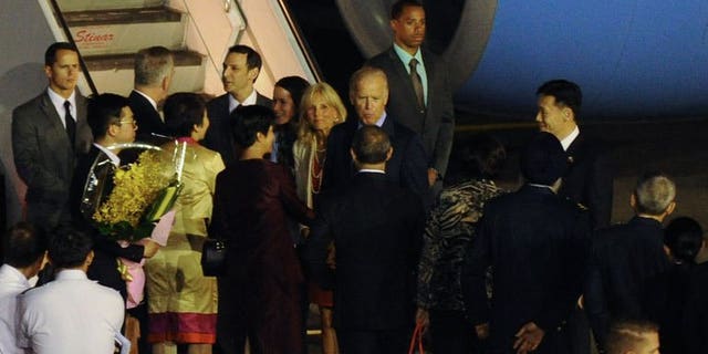 US Vice President Joe Biden (centre R) with his wife Jill Biden (centre L) greeted by officials upon arrival at the Paya Lebar military airport in Singapore on July 25, 2013. Biden arrived in Singapore on Thursday for a visit in which he is expected discuss trade ties and ways to calm regional maritime tensions.