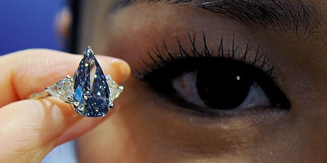 A model holds a 'De Beers Millennium Blue Diamond' valued at an estimated $ 4.6-5.9 mn in Hong Kong in 2010. The world's top diamond producer De Beers on Friday reported "steady" total first-half sales of $3.3 billion (2.5 billion euros), unchanged from the outcome in the first half of 2012.