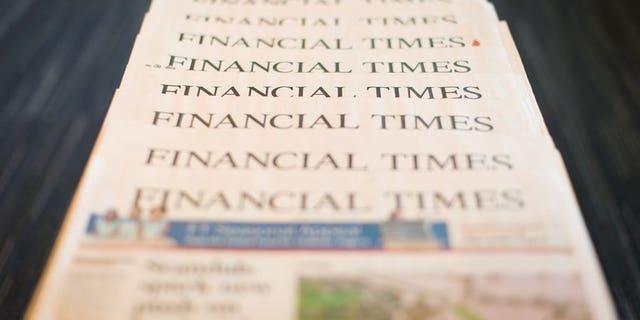 Copies of Pearson's Financial Times newspaper for December 11 last year. British publisher Pearson fell into a first-half net loss on the back of restructuring costs, the group said on Friday, but better-than-expected revenues sent its share price surging.
