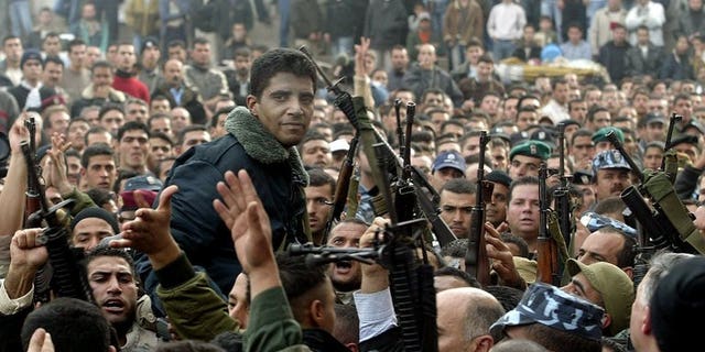 Palestinian militant leader Zakaria Zubeidi (center) and supporters take part in a rally in the West Bank town of Jenin on December 30, 2004. Zubeidi's brother, Daoud Zubeidi, was arrested by Israeli security forces on Friday, Palestinian security forces said.