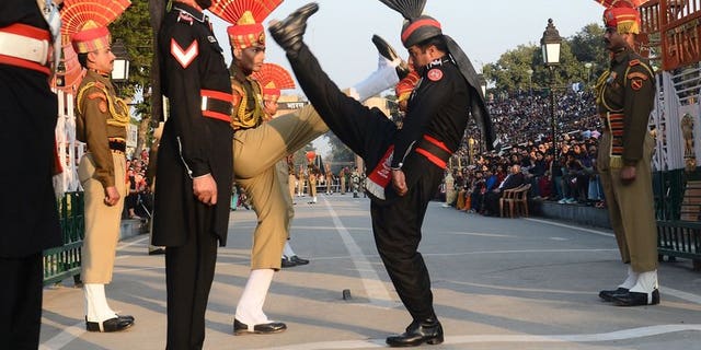 Pakistani (in black) and Indian border troops perform the 'flag off' ceremony at Wagah border post. Indian troops shot and killed one Pakistani soldier and injured another in an "unprovoked" attack across the countries' disputed border in Kashmir, Pakistan's army said Saturday.