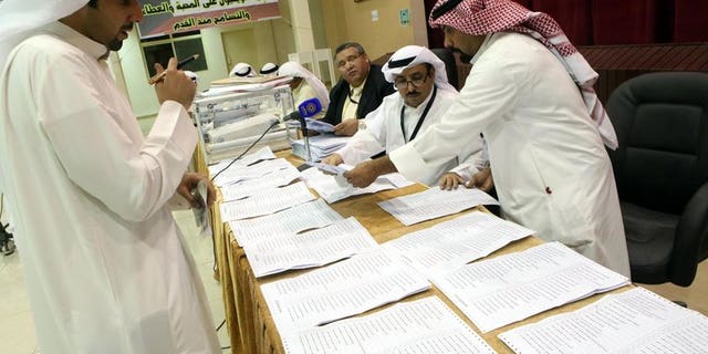Judges and their aides count the ballots at a polling station in Kuwait City on July 27, 2013. Kuwait's Shiite minority lost more than half of their seats and liberals made slight gains in the Gulf state's second polls in eight months.