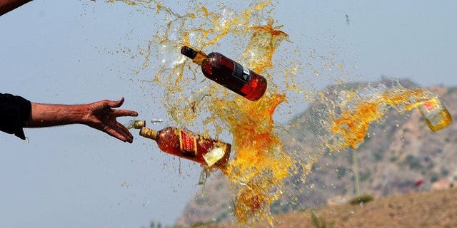 This file photo shows Pakistani officials destroying contraband alcohol, in the Shahkas area of the Jamrud Khyber Agency, on June 26, 2013. At least 18 people died and around two dozen others suffered serious health issues after partygoers at two separate events consumed toxic drinks in central Pakistan, officials said on Sunday.