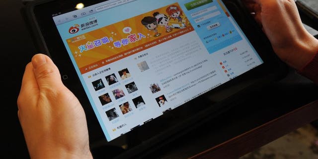 A woman views the Chinese social media website Weibo at a cafe in Beijing on April 2, 2012. A Chinese singer who was detained for threatening to bomb government offices after a man detonated a device at Beijing airport has triggered a debate about free speech.