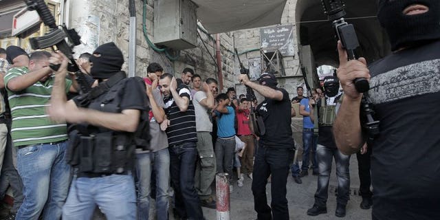 Militants of Al-Aqsa Martyrs' Brigade fire celebratory shots during a ceremony for group member Jamal Nablusi in the West Bank city of Nablus on June 2, 2013 following his release from Israeli prison after serving eight years. As negotiators headed to Washington for the resumption of peace talks on Monday, most Israeli newspapers hit out at the decision to free 104 prisoners in return.