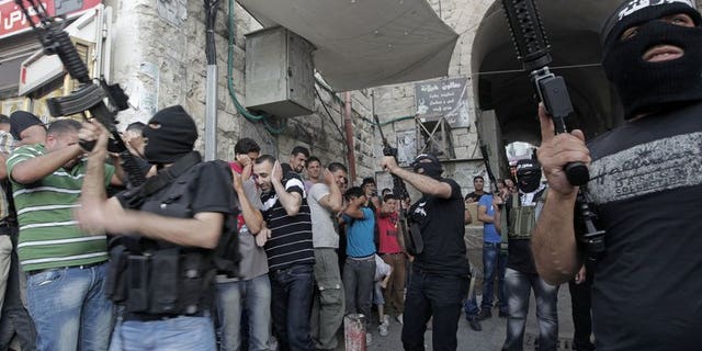Militants of Al-Aqsa Martyrs' Brigade fire celebratory shots during a ceremony for group member Jamal Nablusi in the West Bank city of Nablus on June 2, 2013 following his release from Israeli prison after serving eight years. As negotiators headed to Washington for the resumption of peace talks on Monday, most Israeli newspapers hit out at the decision to free 104 prisoners in return.