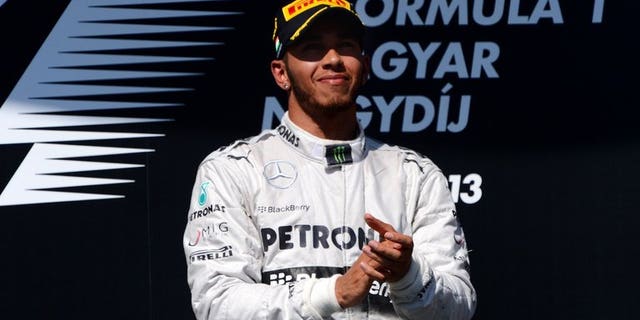 Mercedes' British driver Lewis Hamilton celebrates on the podium at the Hungaroring circuit in Budapest on July 28, 2013. Hamilton's faith in Mercedes was repaid by a victory that will give him the momentum to mount a title bid in the second half of the Formula One season, according to team chief Ross Brawn.