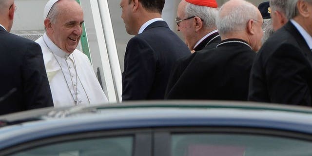 Pope Francis (L) speaks with Italian interior minister and deputy premier Angelino Alfano (C) after disembarking from his plane at Rome's Ciampino international airport on July 29, 2013. Pope Francis on Monday condemned the gay lobby but said that homosexuals should not be marginalised.