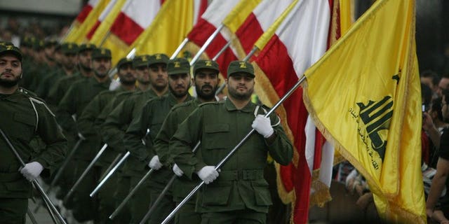 Hezbollah fighters hold up Lebanese flags and the yellow flag of the militant Shiite Muslim group in Beirut on November 11, 2009. Nigerian prosecutors on Monday widened charges against three Lebanese nationals accused of links to Hezbollah as their trial began with access to the courtroom restricted and the identities of witnesses concealed.