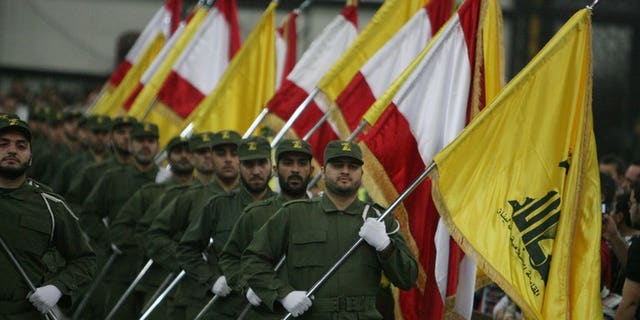 Hezbollah fighters hold up Lebanese flags and the yellow flag of the militant Shiite Muslim group in Beirut on November 11, 2009. Nigerian prosecutors on Monday widened charges against three Lebanese nationals accused of links to Hezbollah as their trial began with access to the courtroom restricted and the identities of witnesses concealed.