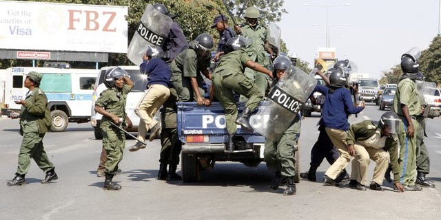 Zambian police officers arrive at the University of Zambia on May 17, 2013 in Lusaka. Zambian police on Monday arrested and charged a journalist with having porn on his computer in another apparent crackdown on a publication critical of the government, his lawyer said.