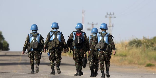 United Nations peacekeepers from the Philippines walk down a road in the Golan Heights on June 12, 2013. The Philippines said Wednesday it would likely keep its 340 soldiers in the Golan Heights as part of a United Nations peacekeeping force, amid improved security for the troops.