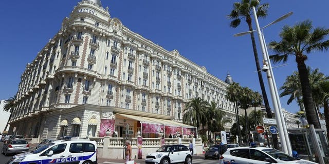 Police cars are parked outside the Carlton Hotel on July 28, 2013 in the French Riviera resort of Cannes, after an armed man held up a jewellery exhibition. Two armed men have held up a store selling luxury watches in the French Riviera resort of Cannes Wednesday, three days after a huge jewellery heist took place at a nearby hotel, a source close to the case said.