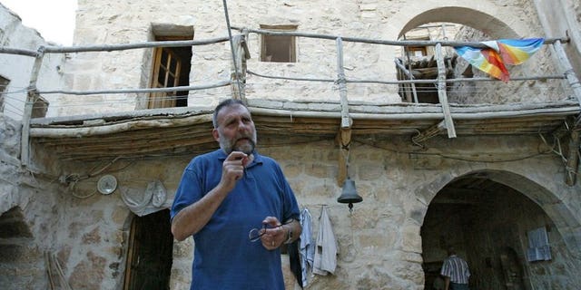 Father Paolo Dall'Oglio stands in a courtyard and talks to a visitor at Syria's historic Monastery of Mar Moussa, on July 11, 2007. Pope Francis has voiced concern over the fate of an Italian Jesuit priest missing in Syria.
