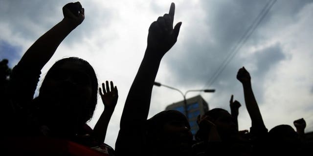 Bangladeshi garment workers shout slogans during a protest in Dhaka, on July 14, 2013. Hundreds of Bangladeshi garment workers have set fire to their factory to demand a better bonus before the country's main Muslim festival. police tell AFP.