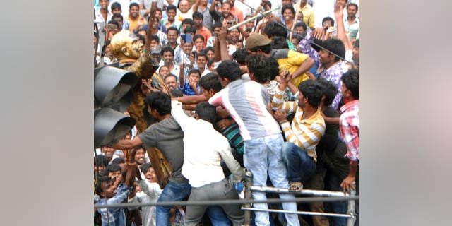 Andhra Pradesh activists tear down a statue of former Indian prime minister Rajiv Gandhi as they demonstrate against the formation of Telangana state in Ananthapur, on July 31, 2013. Protests have erupted in southeast India a day after the national ruling coalition approved the creation of a new state, leading to hundreds of arrests, police and reports said.