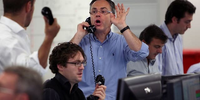 Brokers on ICAP's dealing floor in London. London shares closed higher on Thursday, lifted by strong results from Guinness maker Diageo as a flood of corporate results swept the market.