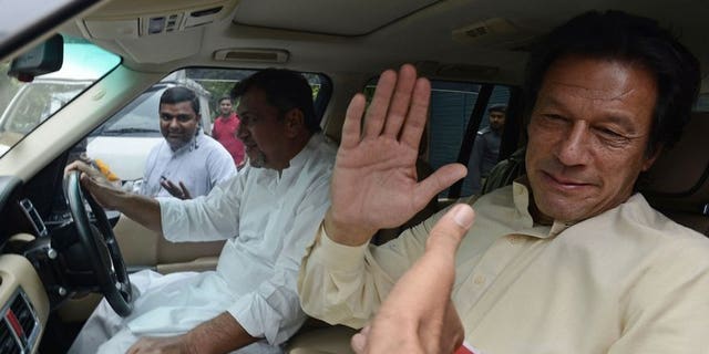 Pakistan Tehreek-e-Insaf (PTI) chairman Imran Khan greets supporters in Lahore on June 13, 2013. Pakistan's top court on Wednesday summoned cricketer-turned-politician Khan for a contempt hearing over his "critical and derogatory" remarks against the judiciary, a statement said.
