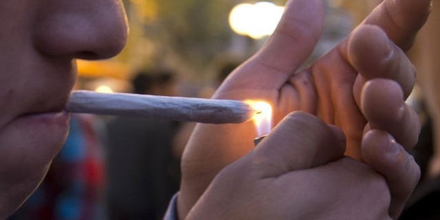 A man lights a marijuana joint during a demonstration demanding a new law on cannabis in Montevideo on May 8, 2013. NGOs argue that "marijuana use has doubled in the last 10 years" in the small, mostly rural South American country of 3.4 million.