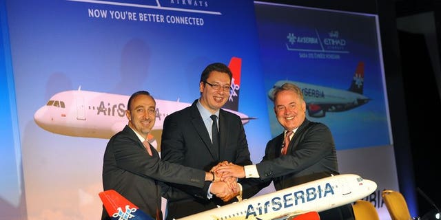 Air Serbia general manager Dane Kondic (left) shakes hands with Serbian Deputy Prime Minister Aleksandar Vucic (centre) and Etihad Airways president James Hogan after signing a partnership agreement in Belgrade, on August 1, 2013. Abu Dhabi-based Etihad Airways has signed an agreement with Serbia to acquire 49 percent of its loss-making JatAirways, which will be rebranded as Air Serbia.
