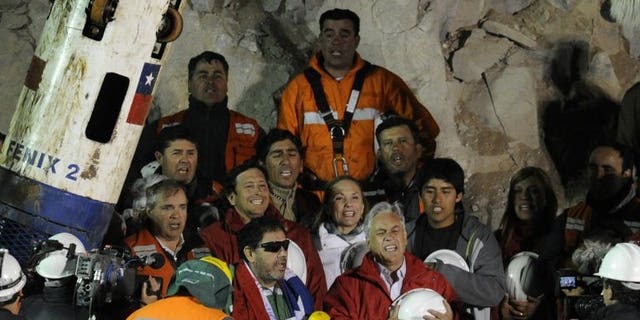The last of the 33 Chilean miners to be rescued, Luis Urzua (C-L), signs the national anthem alongside Chilean President Sebastian Pinera (C-R) and rescue workers, near Copiapo, Chile on October 13, 2010. Three years after 33 trapped Chilean miners were rescued in an operation that captivated the world, an investigation into the site's management closed without any charges.